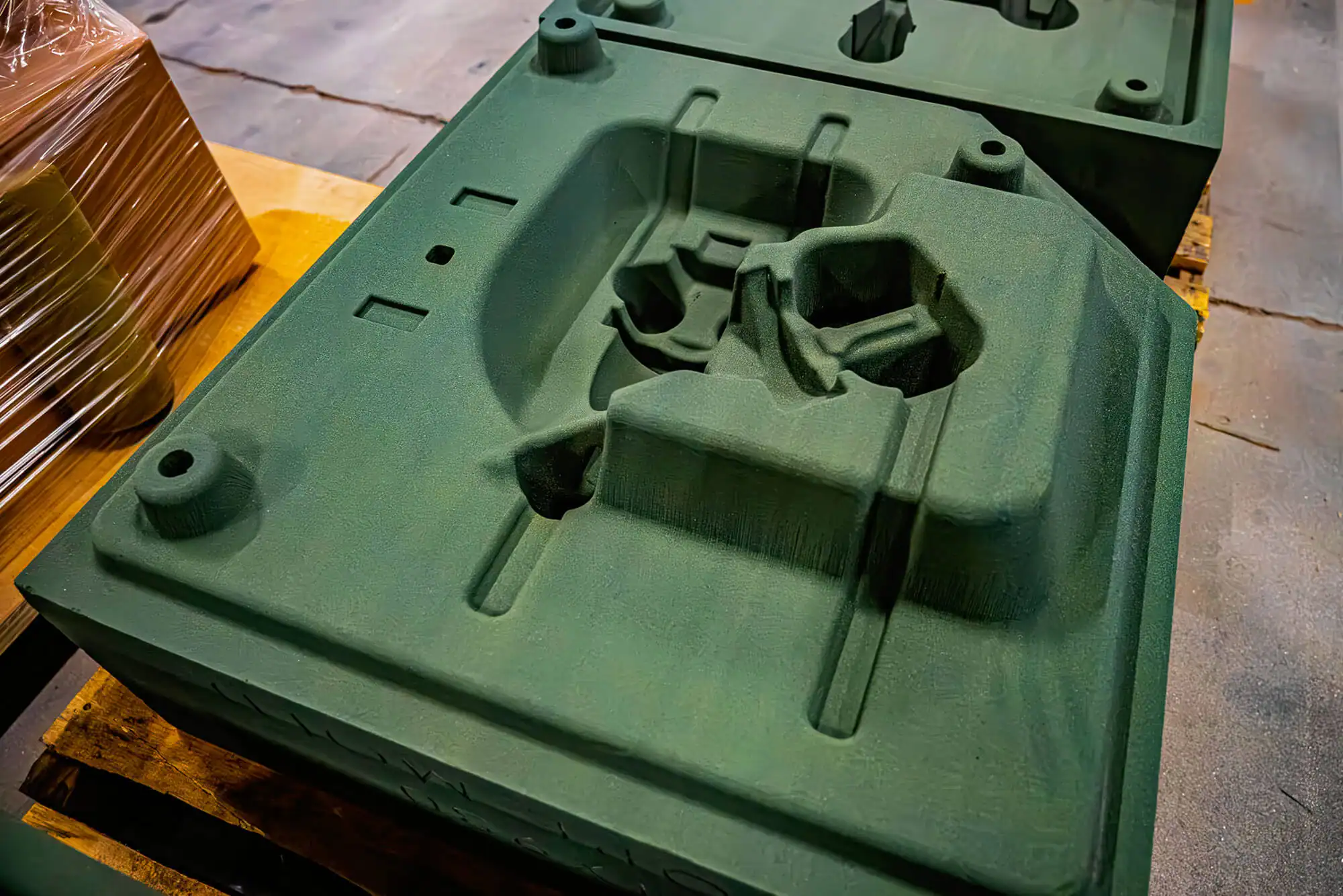 Large 3D printed sand mold rests on a pallet.