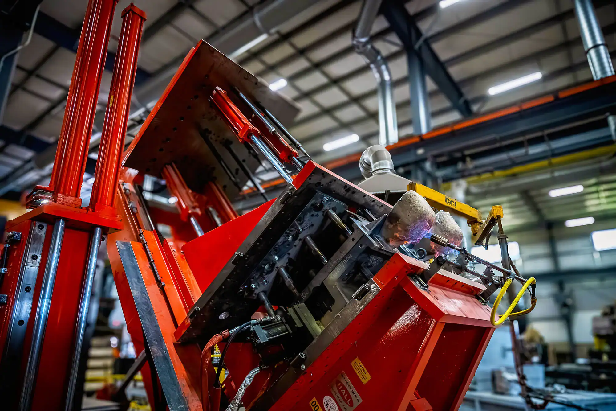 Angle view looking up at tilt pour permanent mold equipment.
