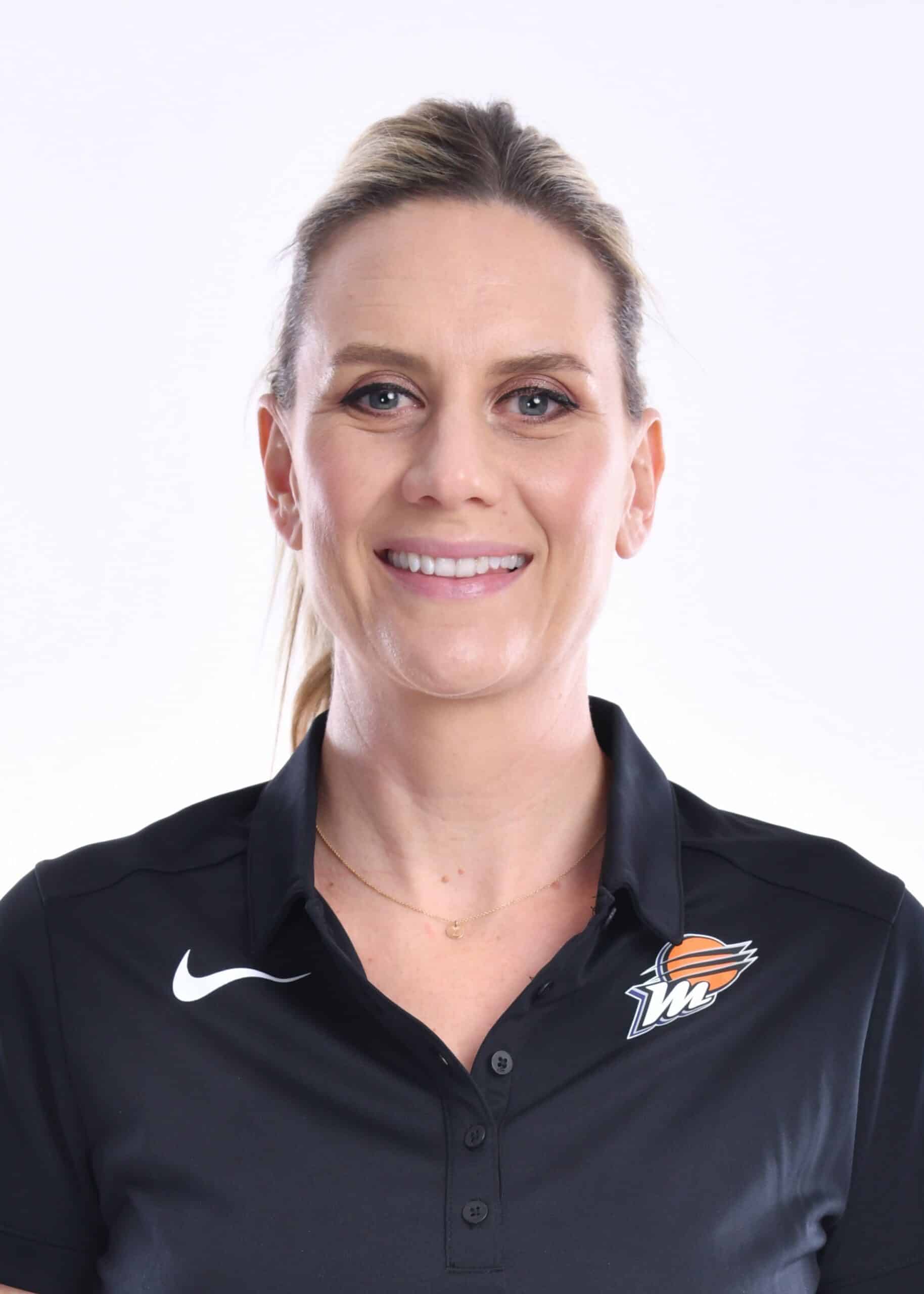 A woman in a black polo posing for a photo.