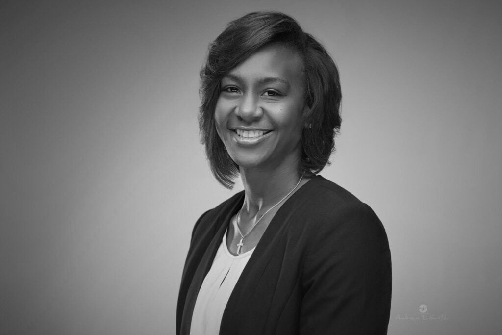 A black and white photo of a woman smiling.