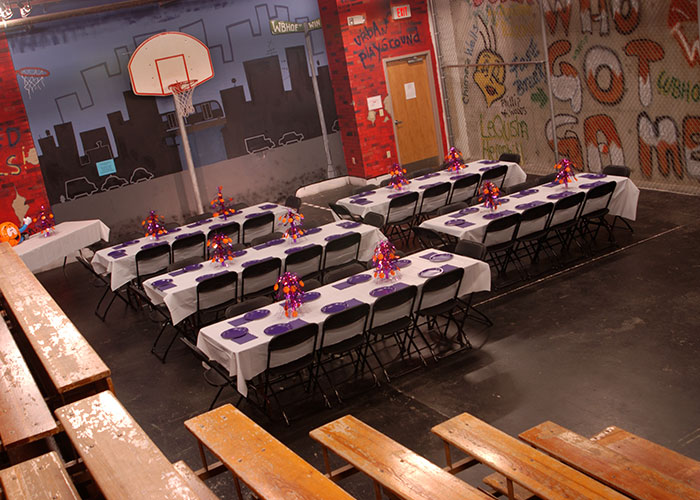 Tables are set up in a basketball court, creating a versatile space for Hall of Fame or youth events. Tables are set up in a basketball court, creating a versatile space for Hall of Fame or youth events.