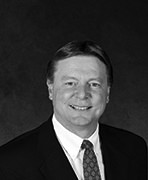 A black and white photo of a man in a suit.