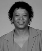 A black and white photo of a woman with curly hair.