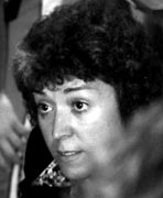 A black and white photo of a woman in a crowd.