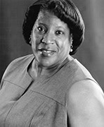 A black and white photo of a woman smiling.