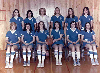A group of women, women's basketball hall of fame members, in blue basketball uniforms posing for a photo. A group of women, women's basketball hall of fame members, in blue basketball uniforms posing for a photo.