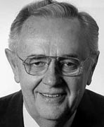 A black and white photo of an older man smiling.