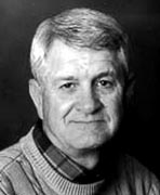 A black and white photo of an older man wearing a sweater.