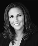 A black and white photo of a woman smiling.