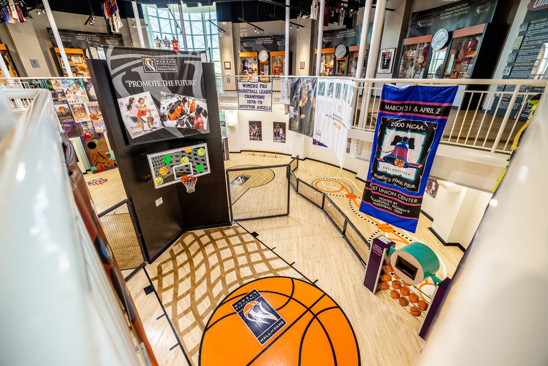 A basketball court in a museum showcasing Hall of Fame posters and banners for youth events. A basketball court in a museum showcasing Hall of Fame posters and banners for youth events.