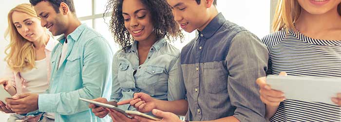 Business team collaborating using digital devices, modern workspace, teamwork, technology, corporate communication, West X Business Solutions.