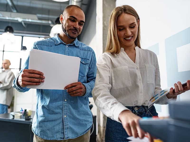 Man and a woman in an office using a printer to scan documents