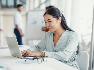 Young woman working on her laptop in a modern workplace