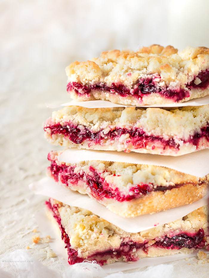 Luscious, buttery, sweet and tart glossy cranberry sauce crumble bars are made with a sweet crumble dough that doubles as a topping. A classic and super easy gorgeous and delicious holiday dessert. You won't be able to eat just one!