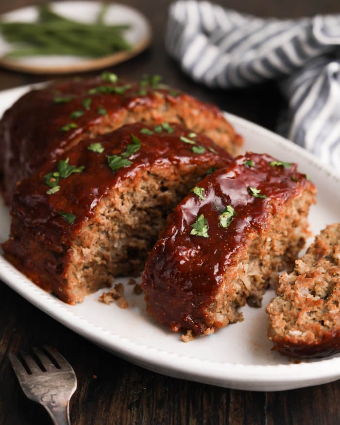 A photo of the Best Meatloaf Recipe with a peppery ketchup and brown sugar glaze on a serving platter 