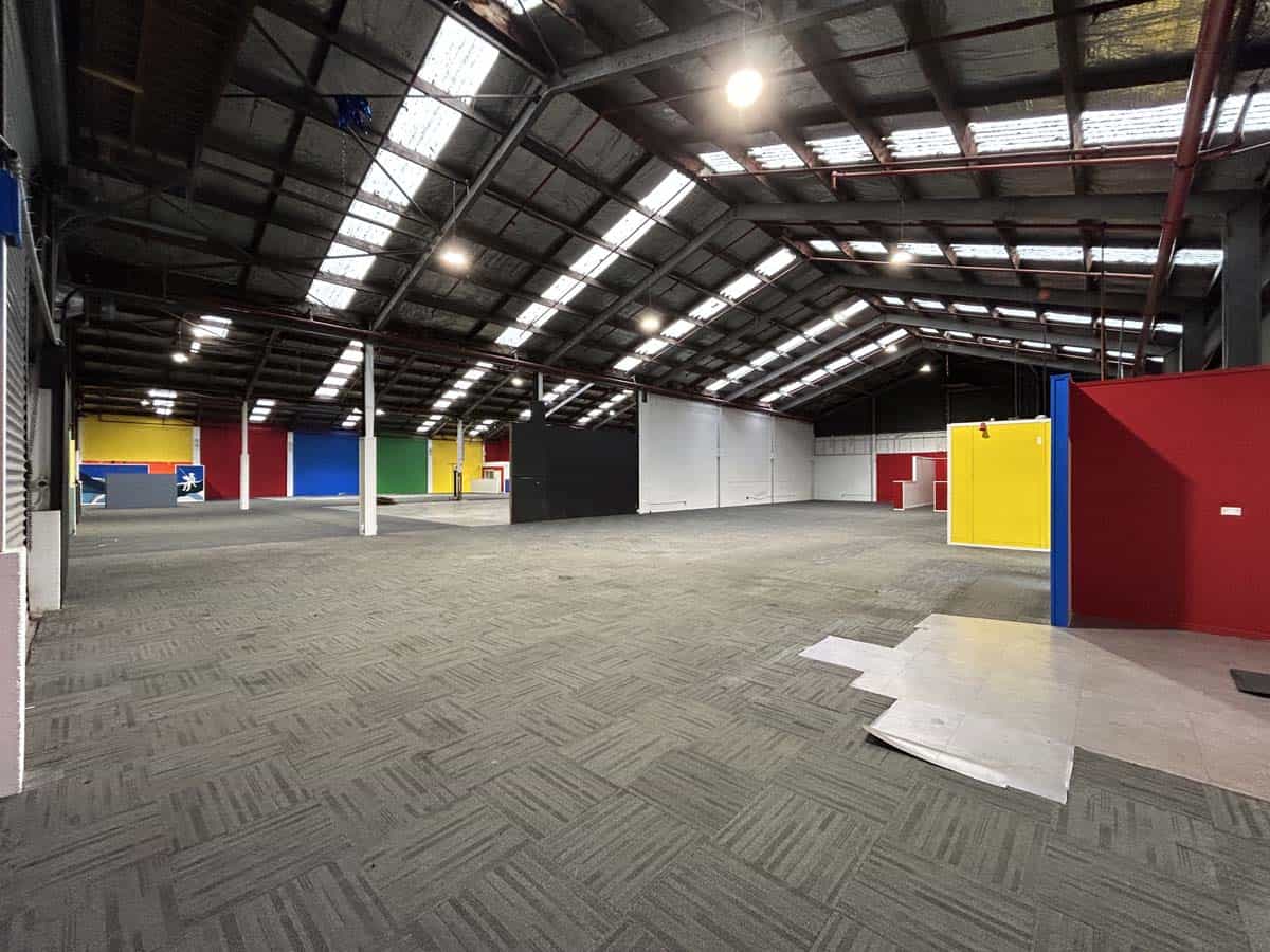 Indoor warehouse with colourful walls and high ceiling for storage or events.