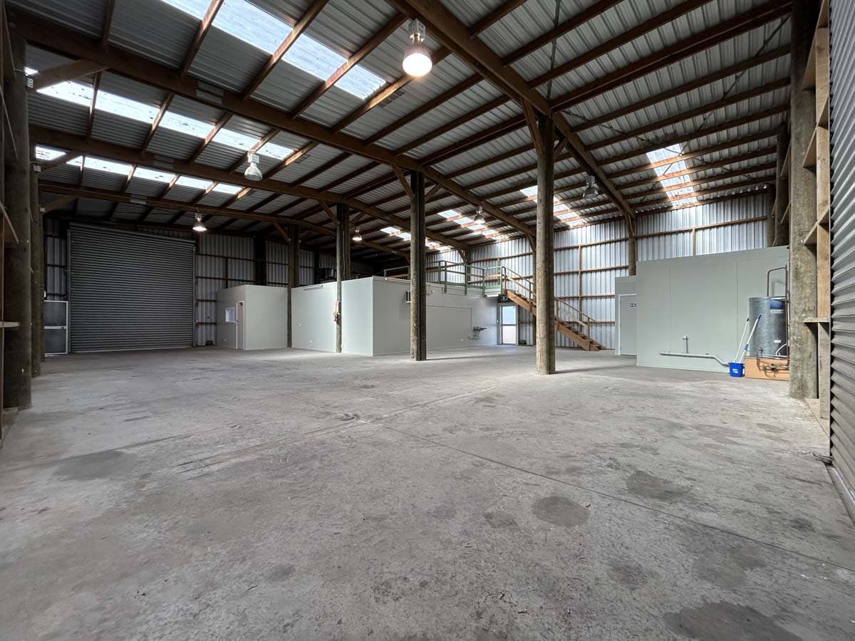 Large empty warehouse with high ceilings and metal structure.