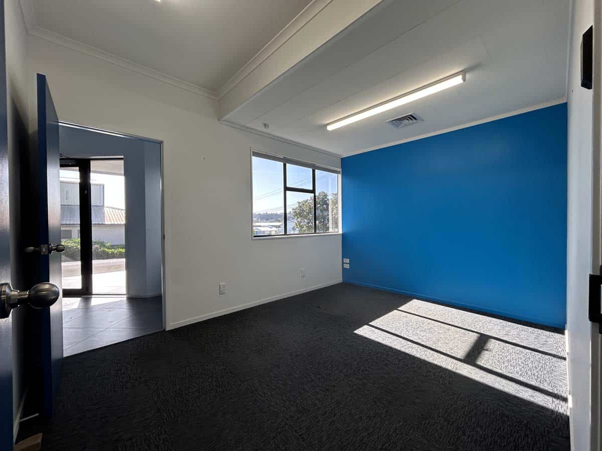 Bright office space with blue accent wall and large windows.