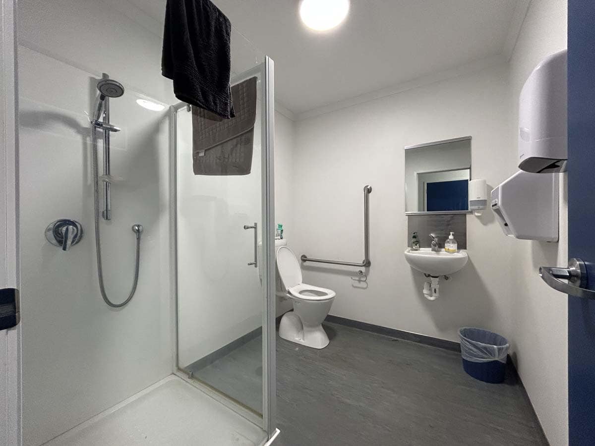 Accessible bathroom with shower, toilet, and sink at 107 De Havilland Drive.