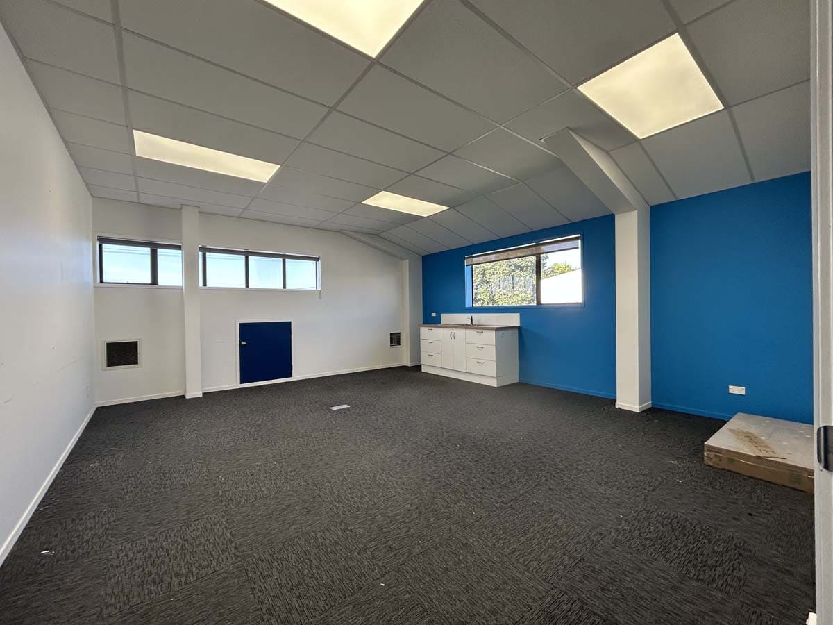 Modern office interior with blue accent wall and natural light.