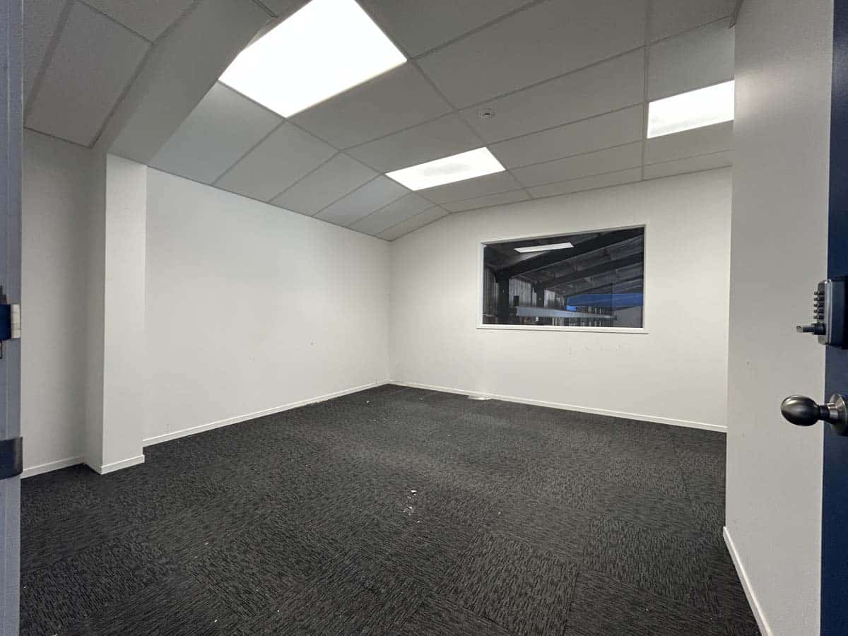 Modern office interior with white walls and ceiling, carpet flooring.
