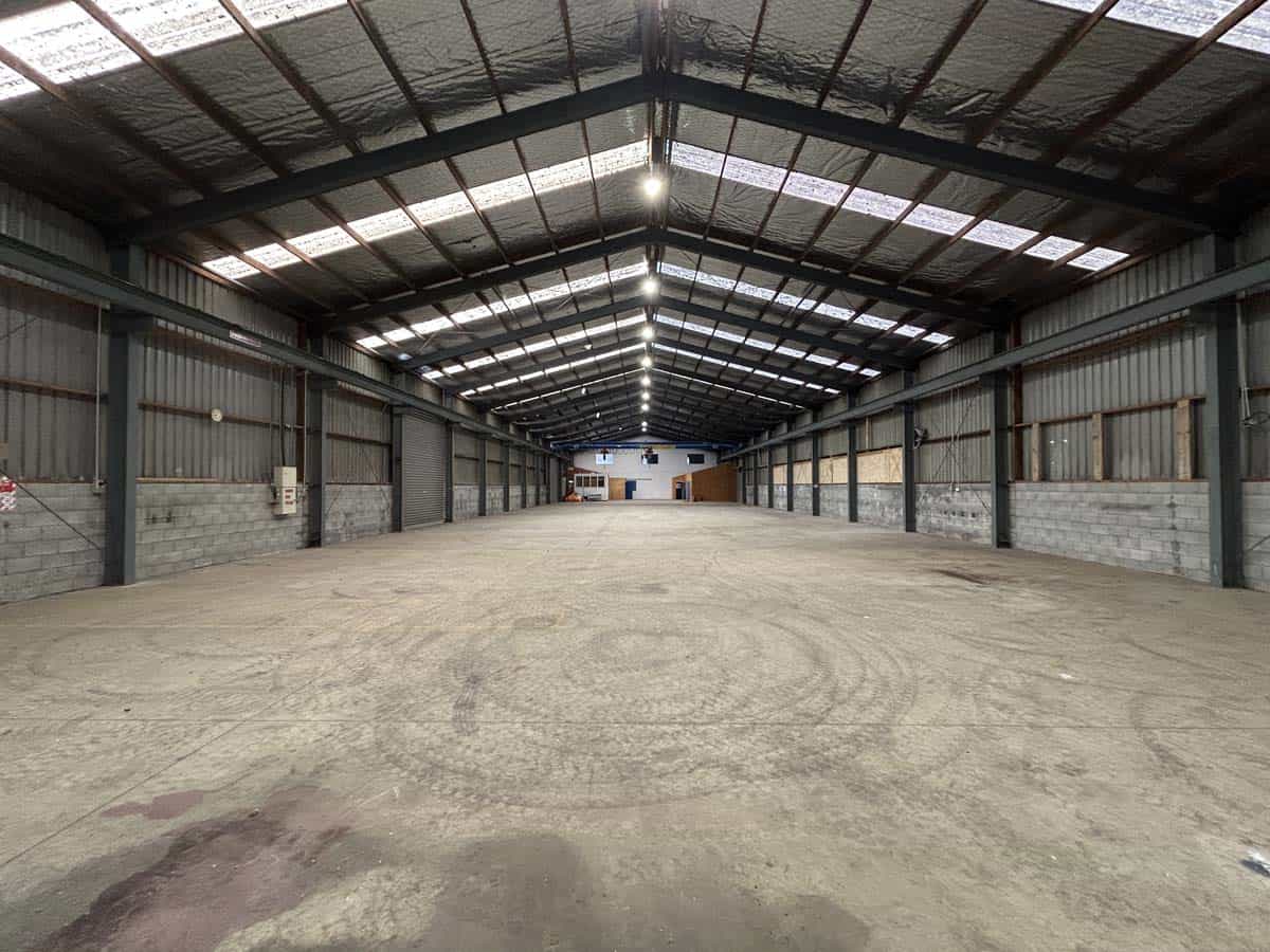Spacious industrial warehouse with high ceilings and ample lighting.
