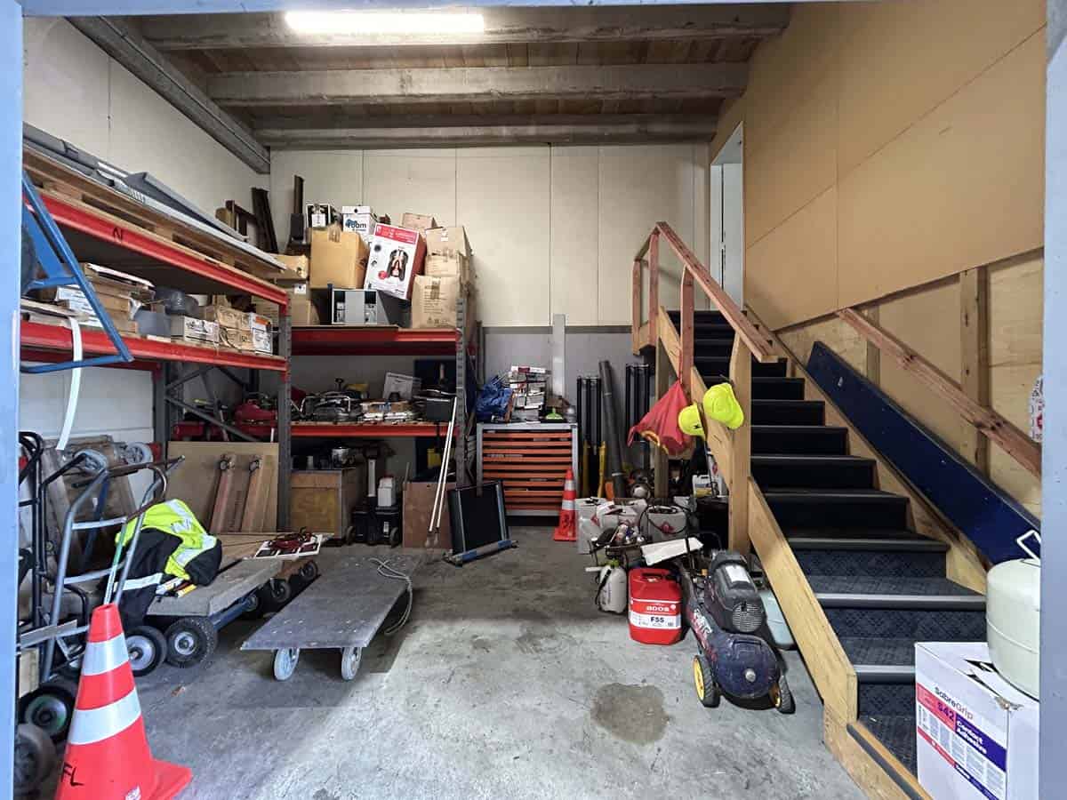 Indoor storage space with tools, equipment, and stairs at 11-13 Lower Tyers Road.