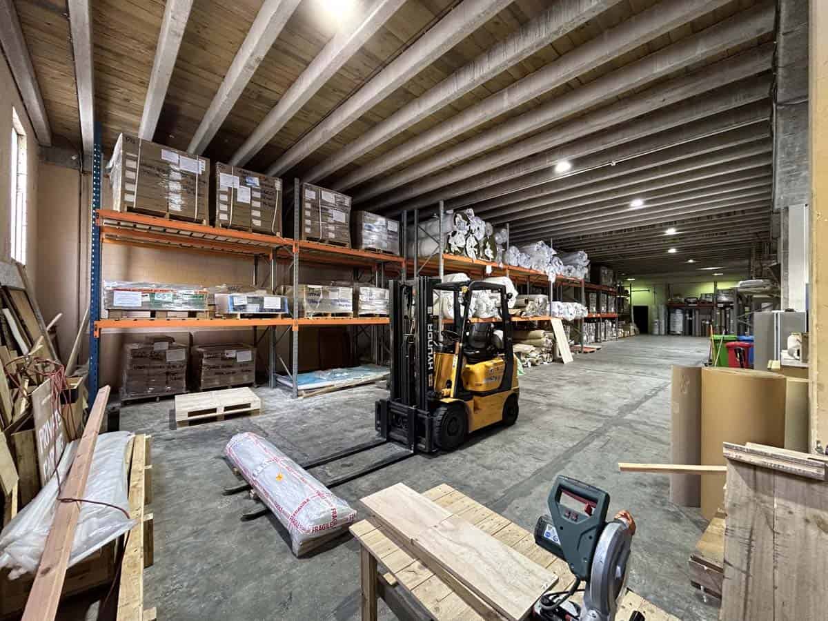 Interior view of a warehouse with shelves, forklift, and stored goods at 11-13 Lower Tyers Road.