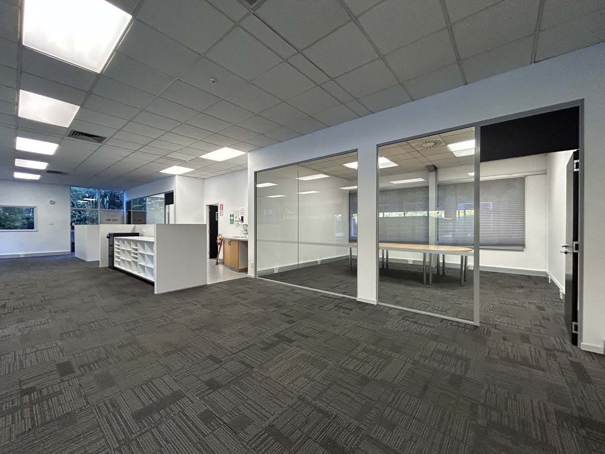 Spacious commercial office space with glass-walled meeting rooms and contemporary design.