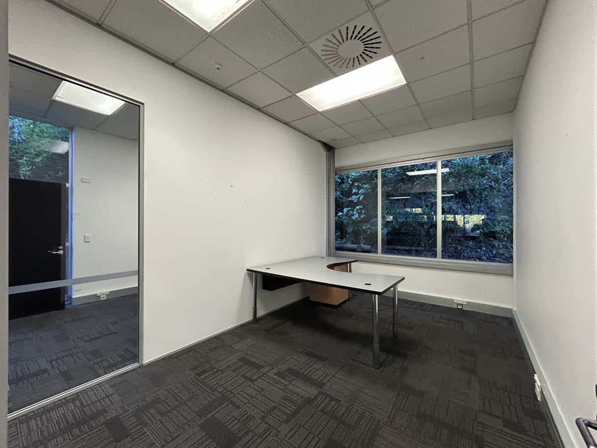 Office space with desk, large window, and natural light.