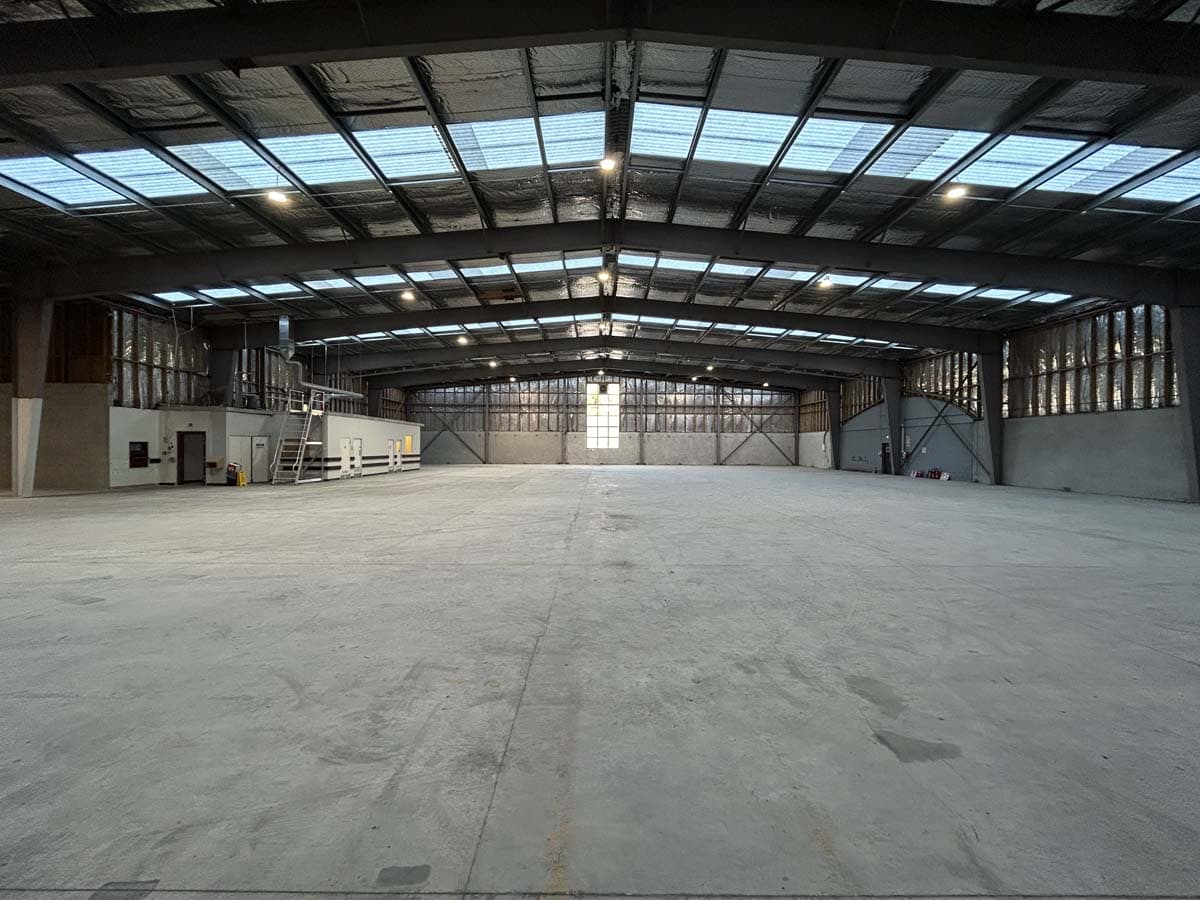 Spacious industrial warehouse with high ceilings and large skylights.