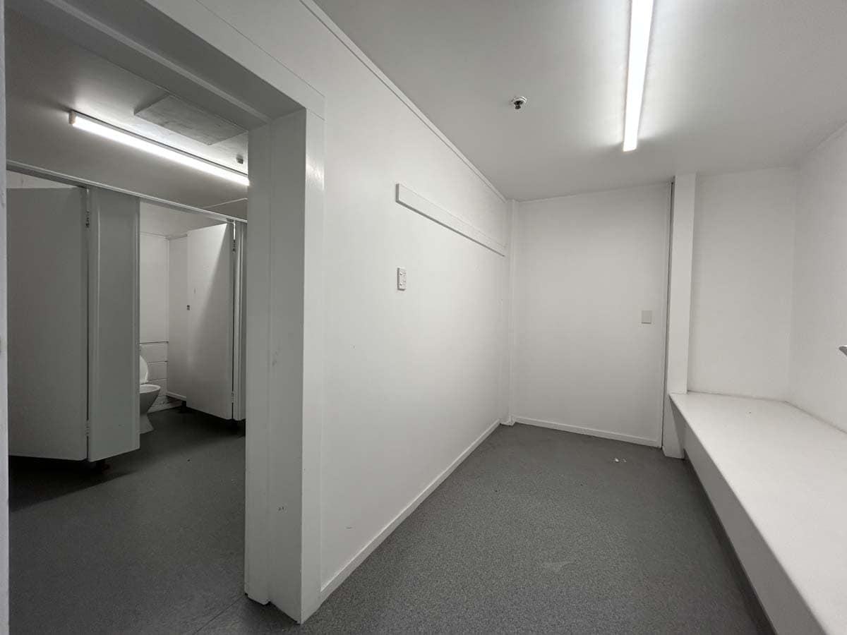 Bright, empty commercial space with white walls and built-in bench.