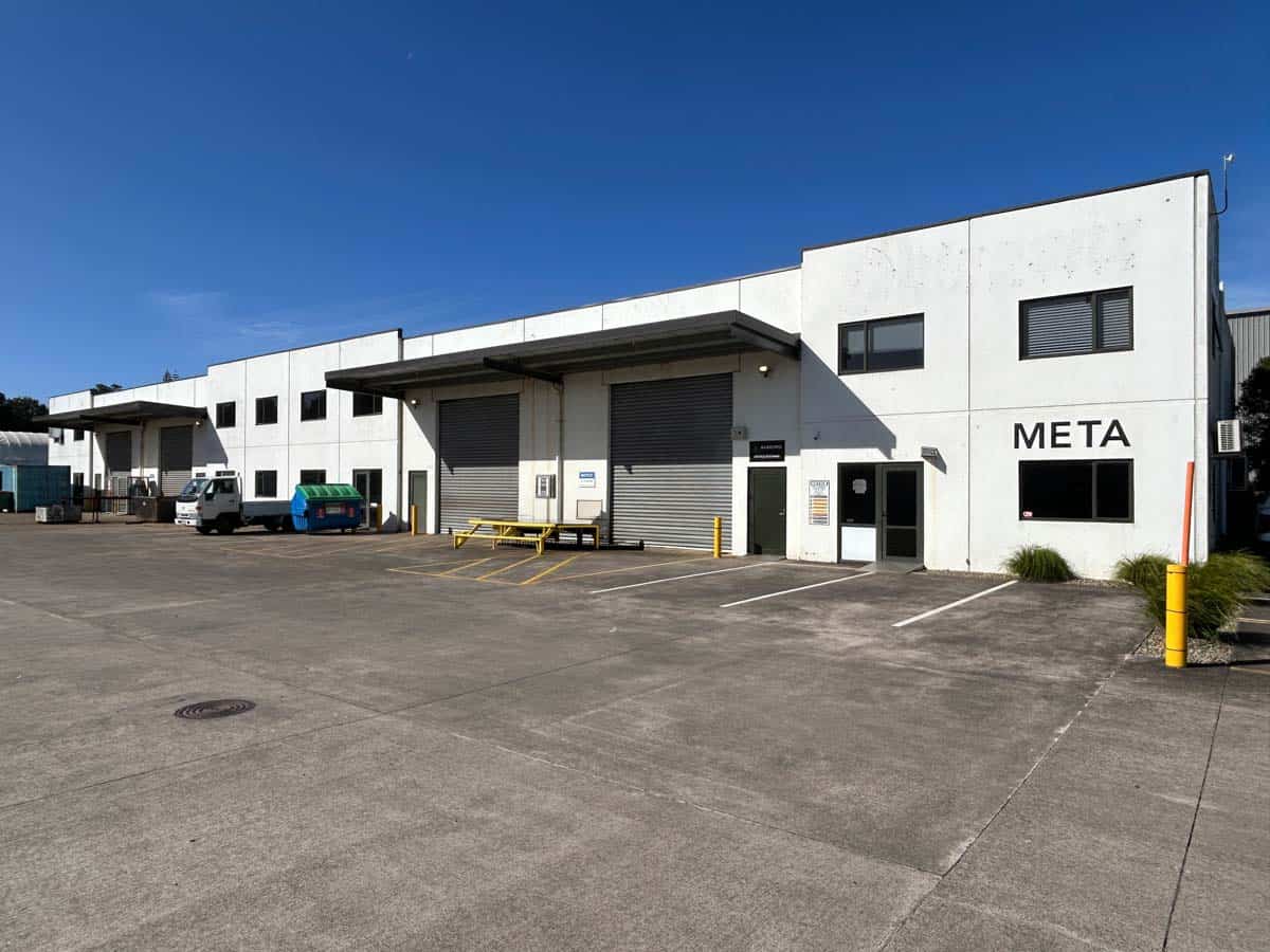 Industrial warehouse building with loading dock and parking area.