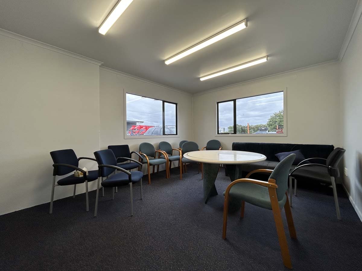 Interior view of a meeting room with chairs and a round table at 211 Connett Road.