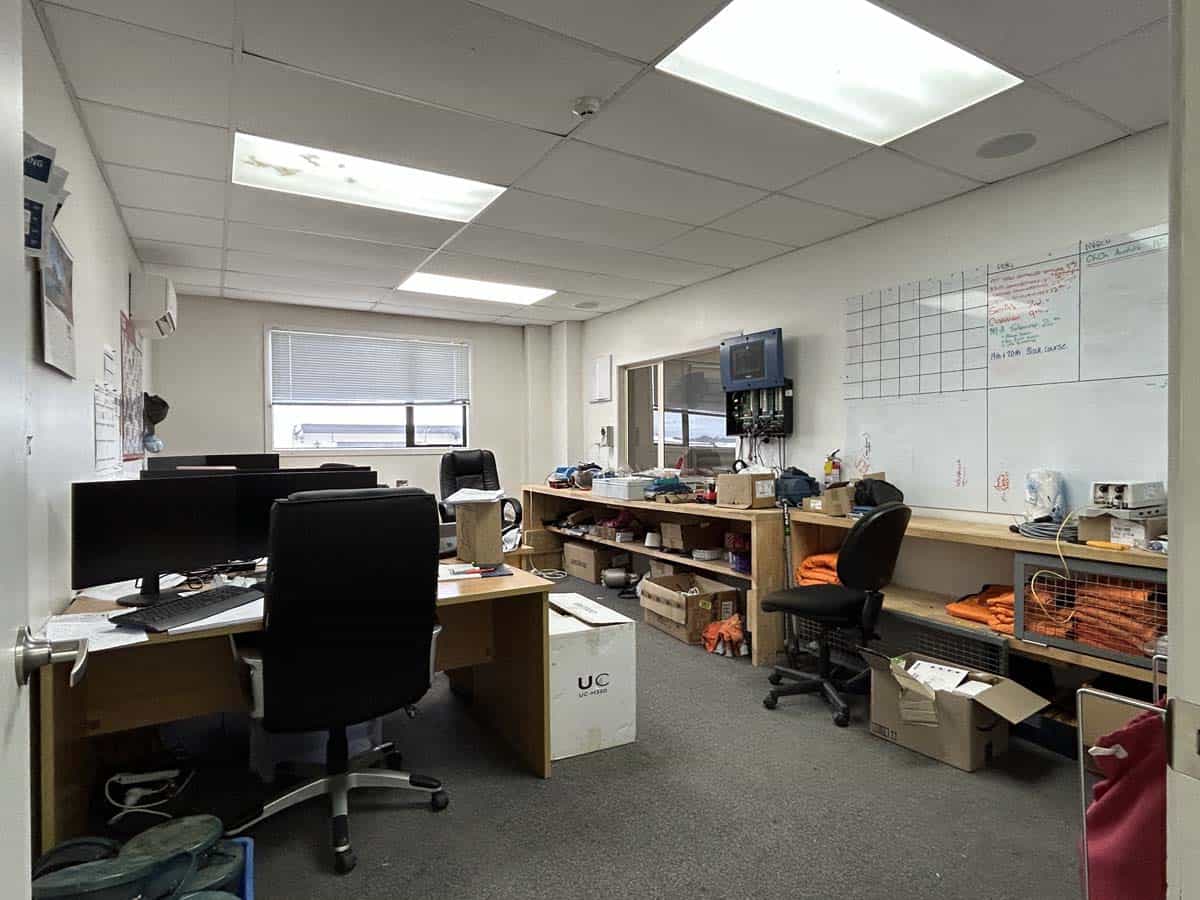 Modern office workspace with desks, chairs, and equipment.