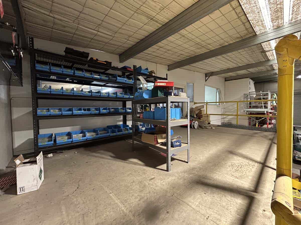 Storage shelves with tools and supplies in industrial warehouse.