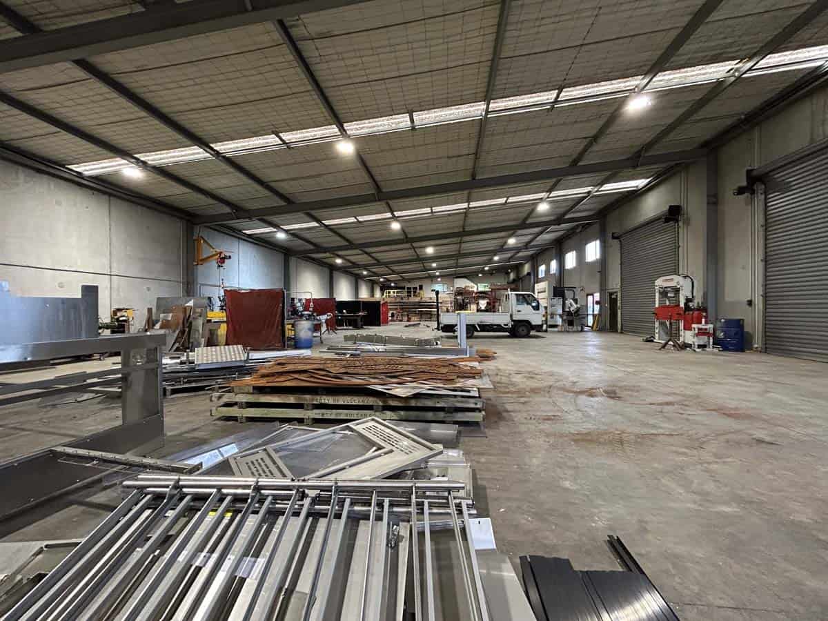 Spacious industrial warehouse with metal racks and equipment.