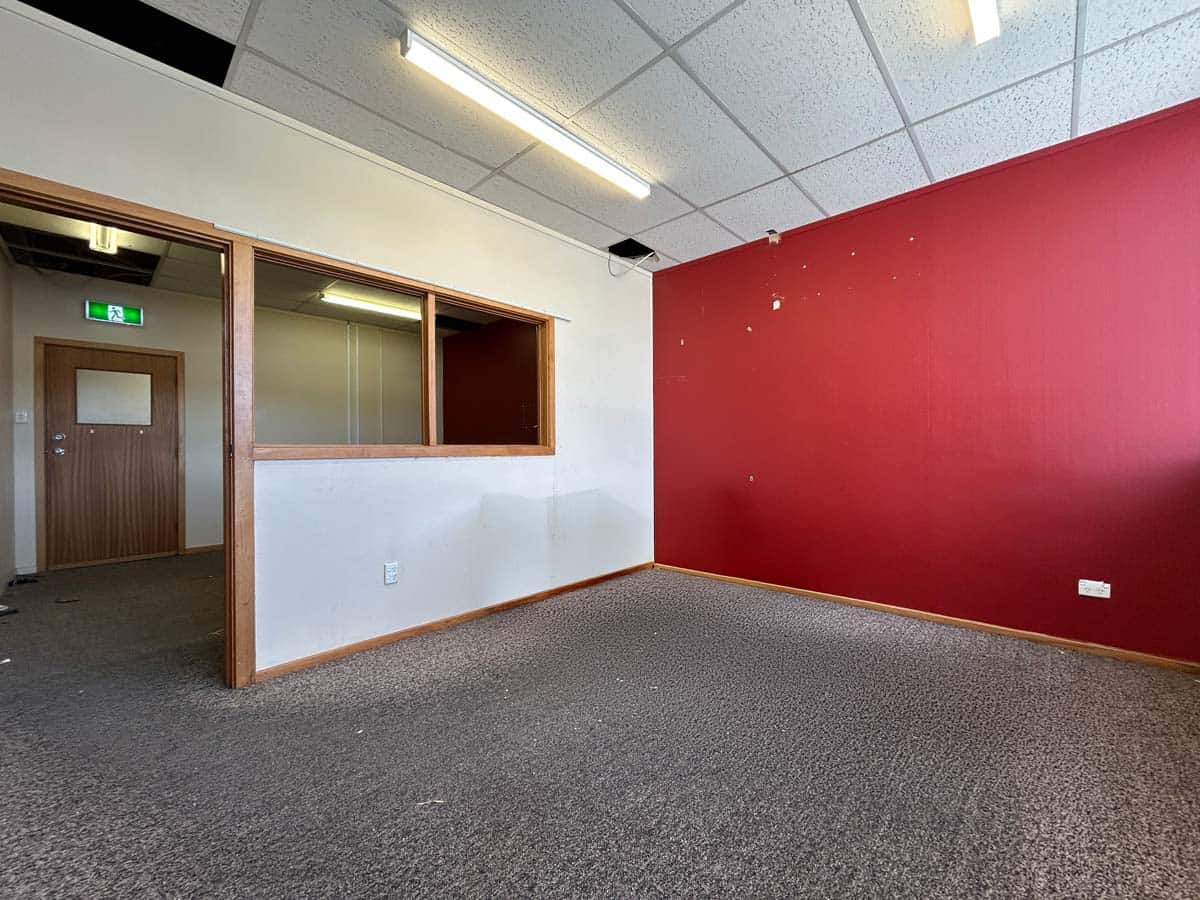 Modern office room with red accent wall and carpeted floor at 31 Johnsonville Road.