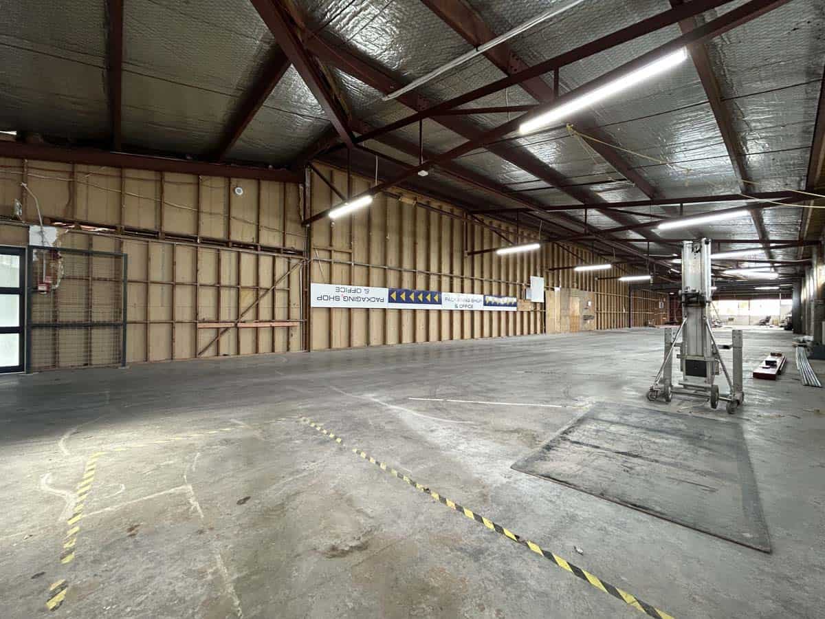 Indoor industrial space with high ceilings and lighting, suitable for storage or manufacturing.