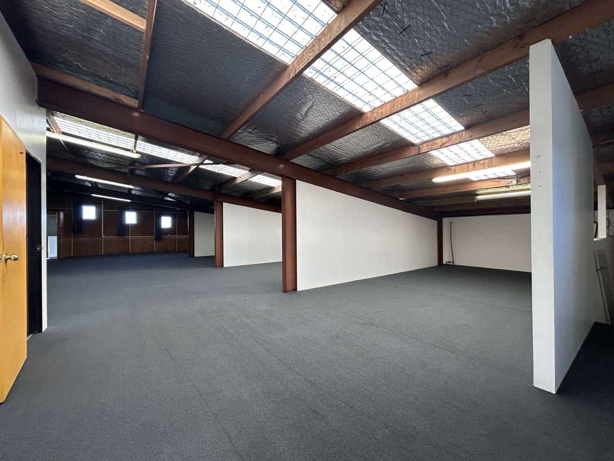 Modern industrial-style office interior with open plan layout and exposed ceiling beams.