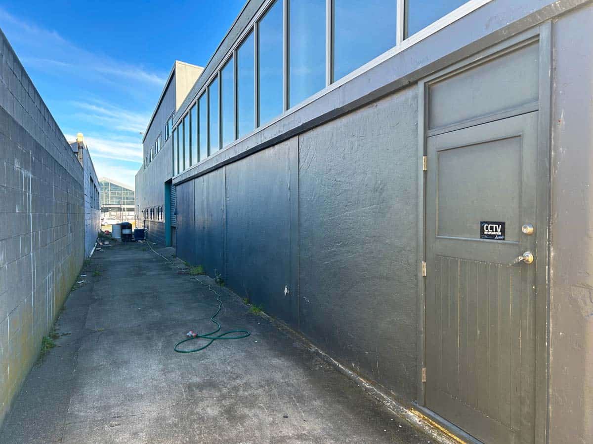 Modern commercial building exterior with large glass windows and a side alley at 45 Waione Street.