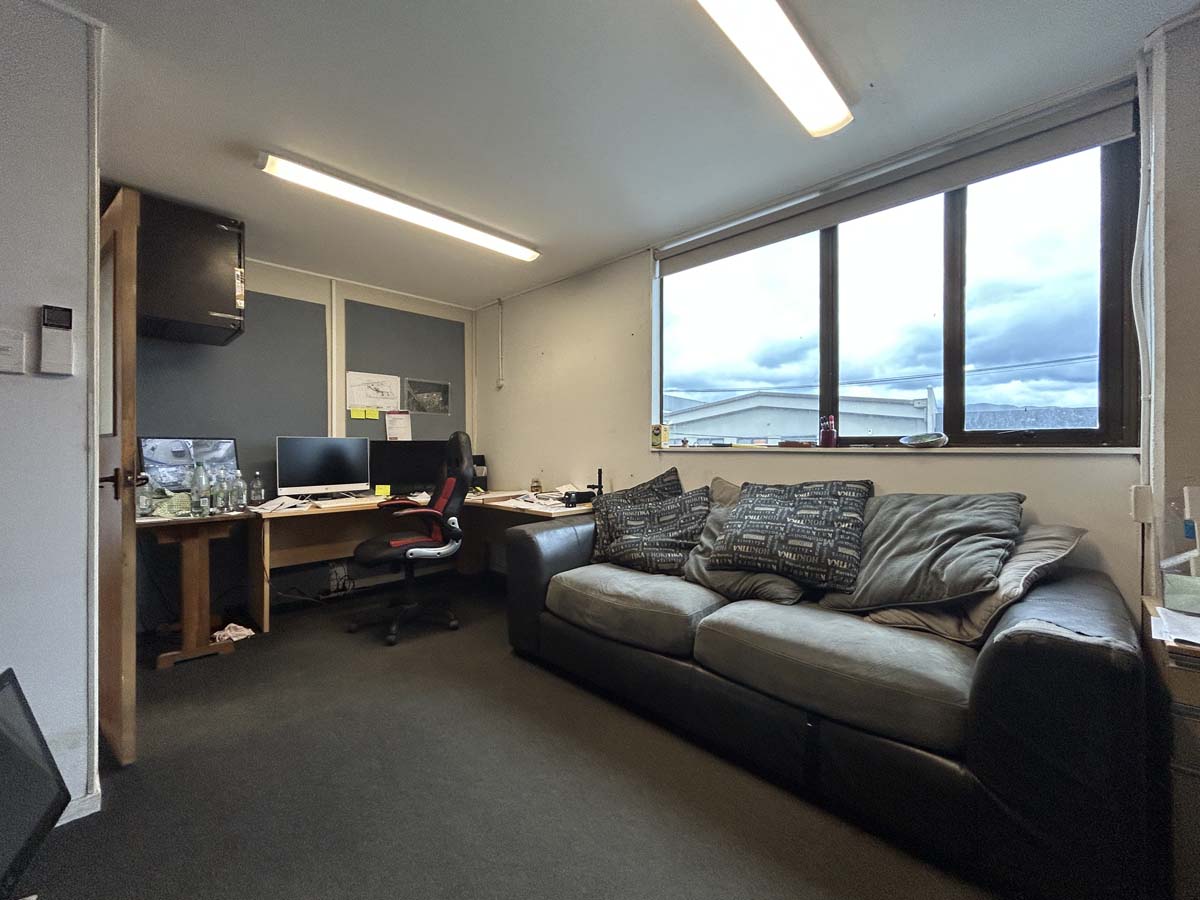 Modern office space with a large window and comfortable seating.