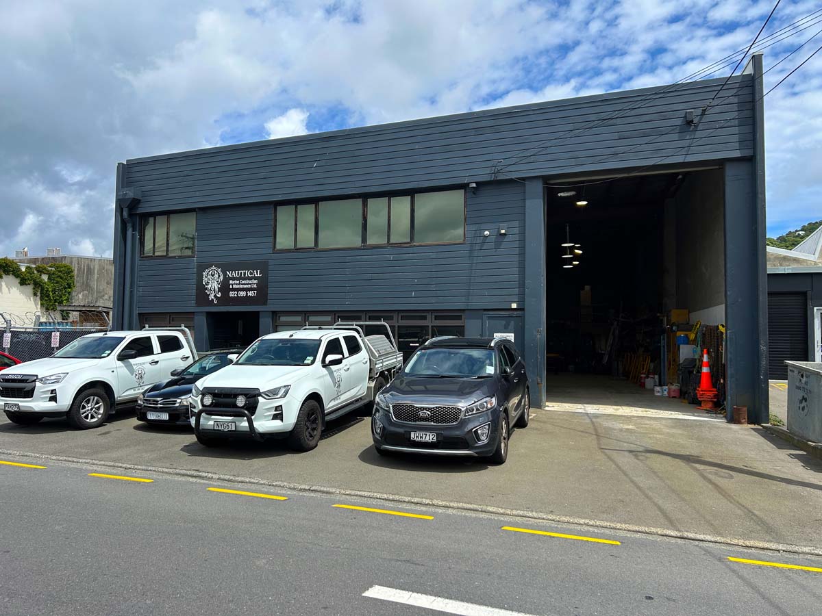 Modern industrial building housing White Lion, with parking and blue sky background.