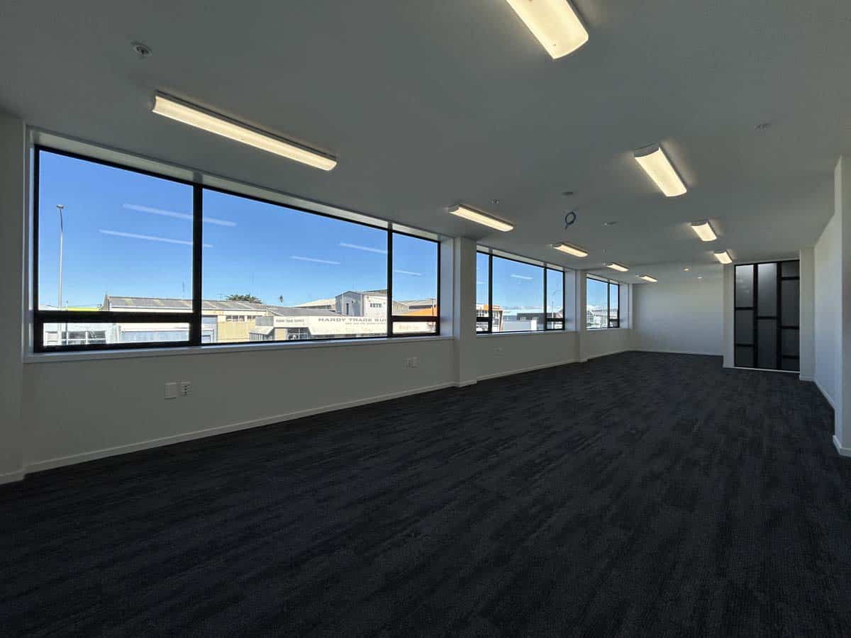 Bright interior office with large windows and modern lighting.