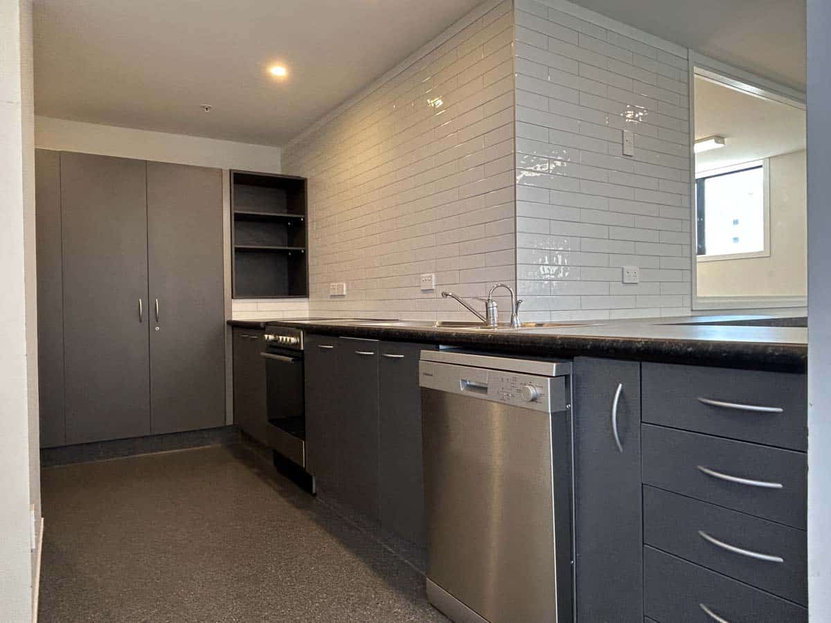 Modern kitchen with grey cabinetry and stainless steel appliances.
