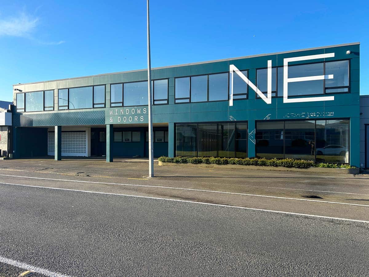 Modern commercial building with large windows and signage in Auckland.