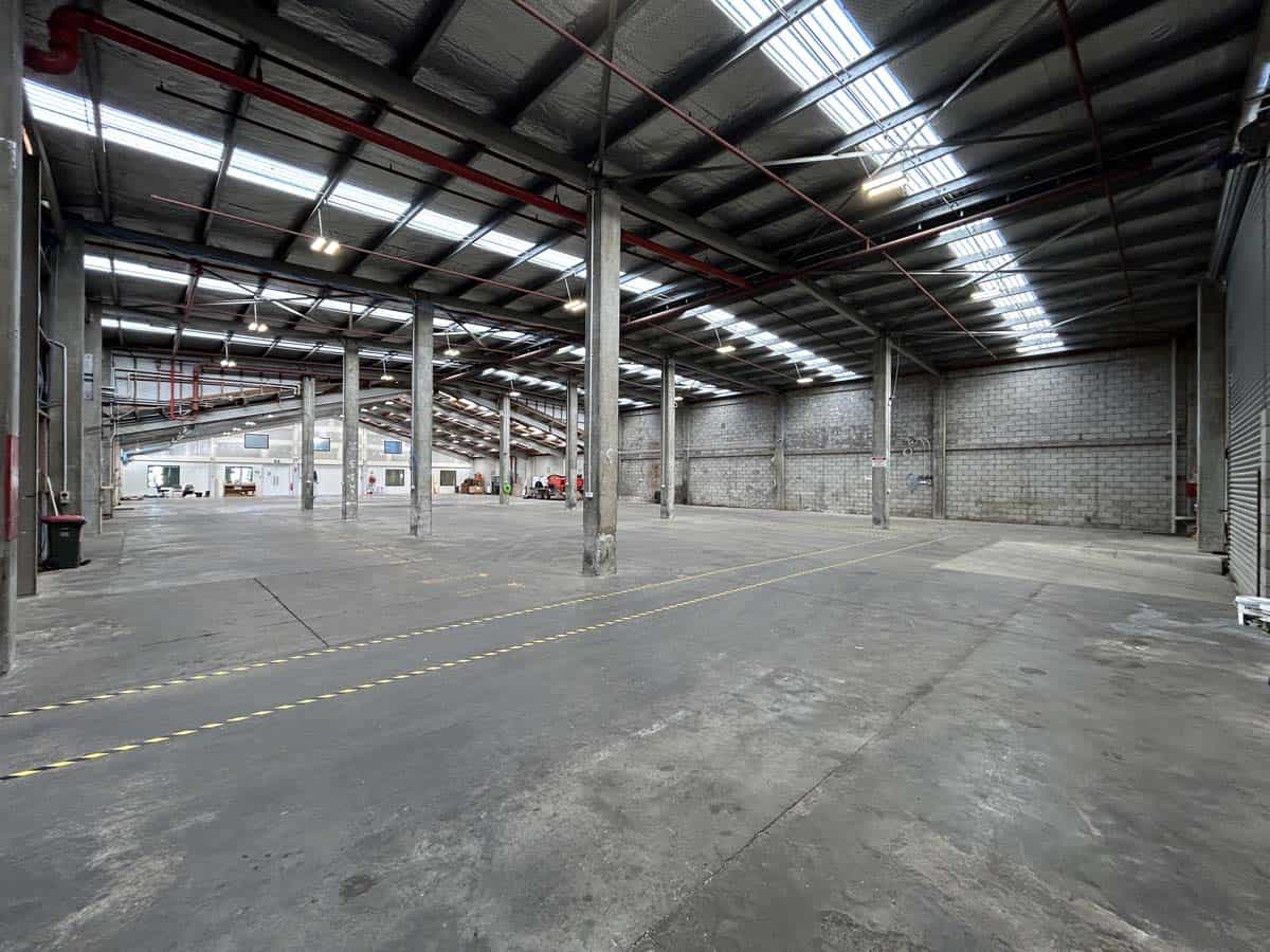Spacious industrial warehouse with high ceilings and steel beams in Auckland.