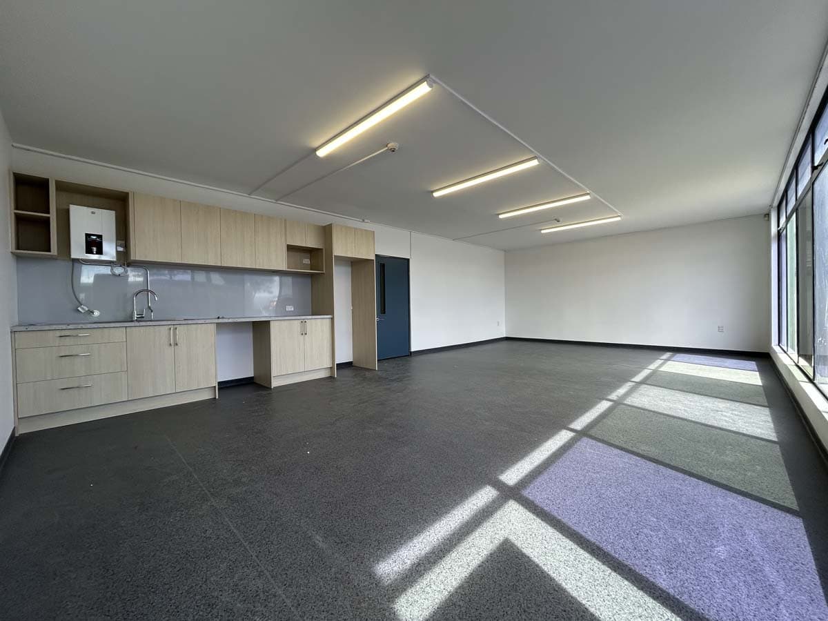 Office interior with large windows, bright lighting, and versatile flooring.