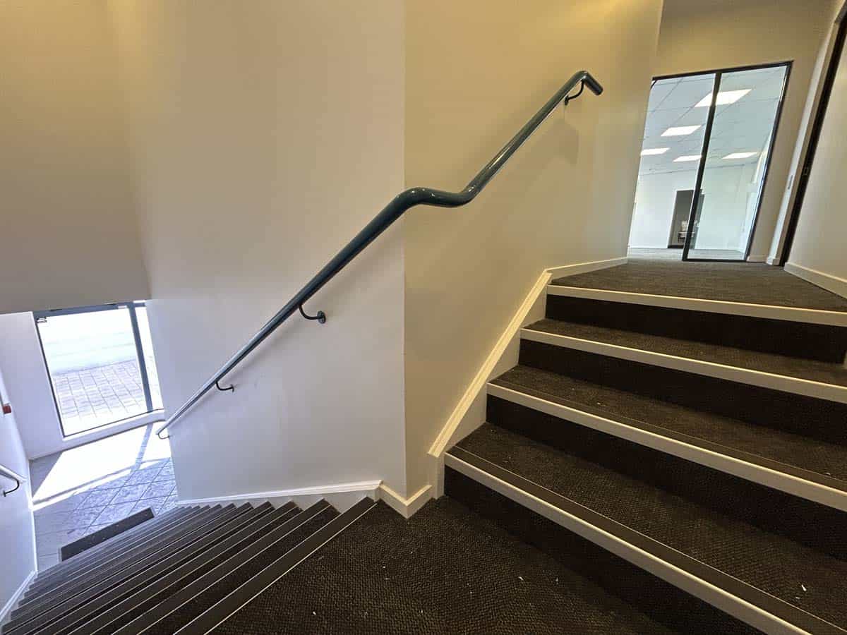 Modern staircase with black steps and handrail at 77 Port Road, White Lion building.