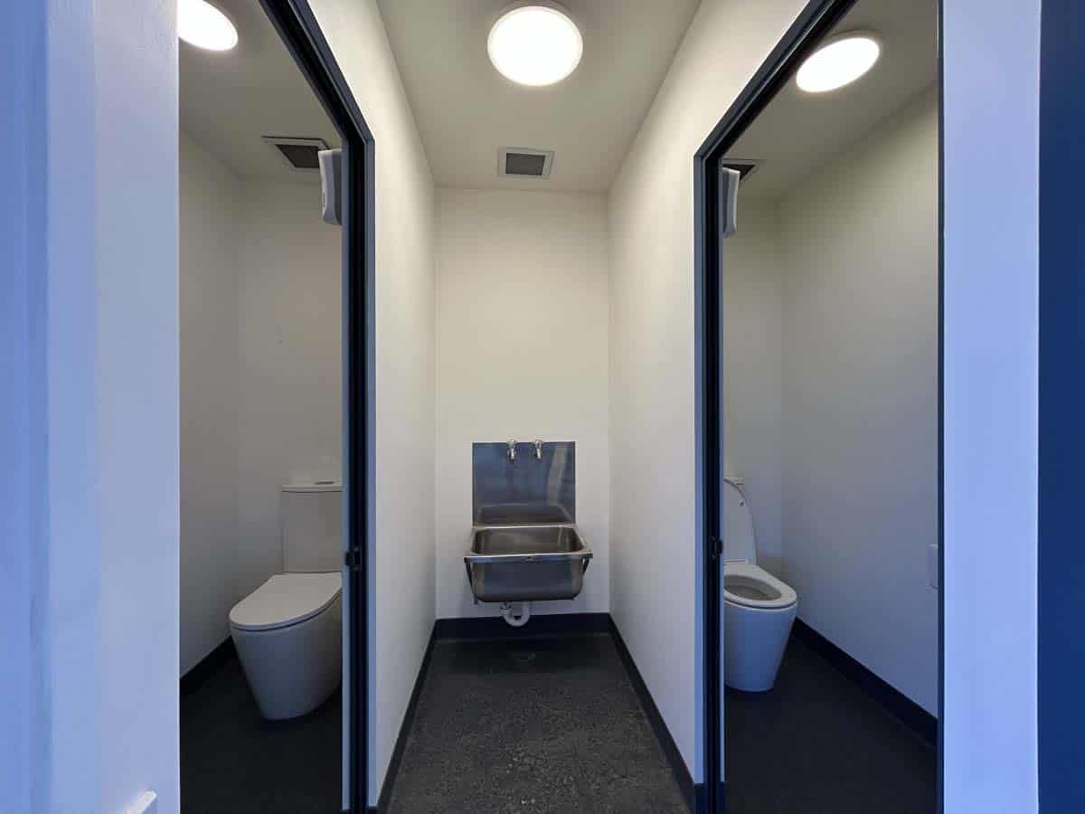 Modern bathroom facilities at White Lion, 77 Port Road, featuring separate toilet stalls.